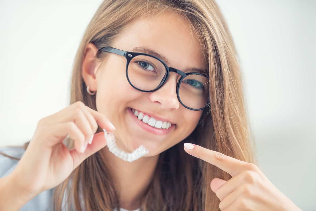 Service Featured Image - teenager smiling with invisalign bracket